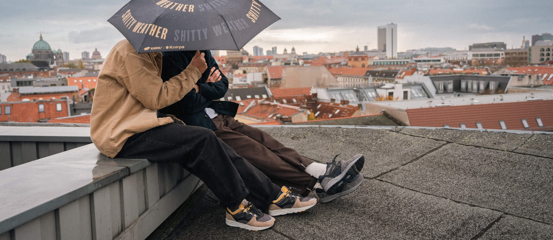 Two people under the Knirps pocket umbrella by Karhu. Two people under the Knirps pocket umbrella by Karhu.